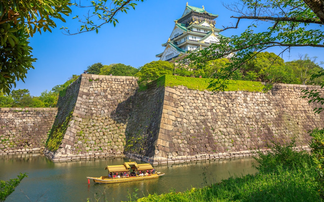 Tourists on a boat in the moat of Osaka Castle, Japan.