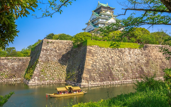 Tourists on a boat in the moat of Osaka Castle, Japan.
