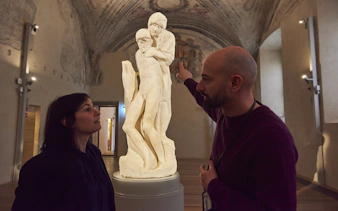 Guide explaining sculpture at Milan Last Supper Museum.