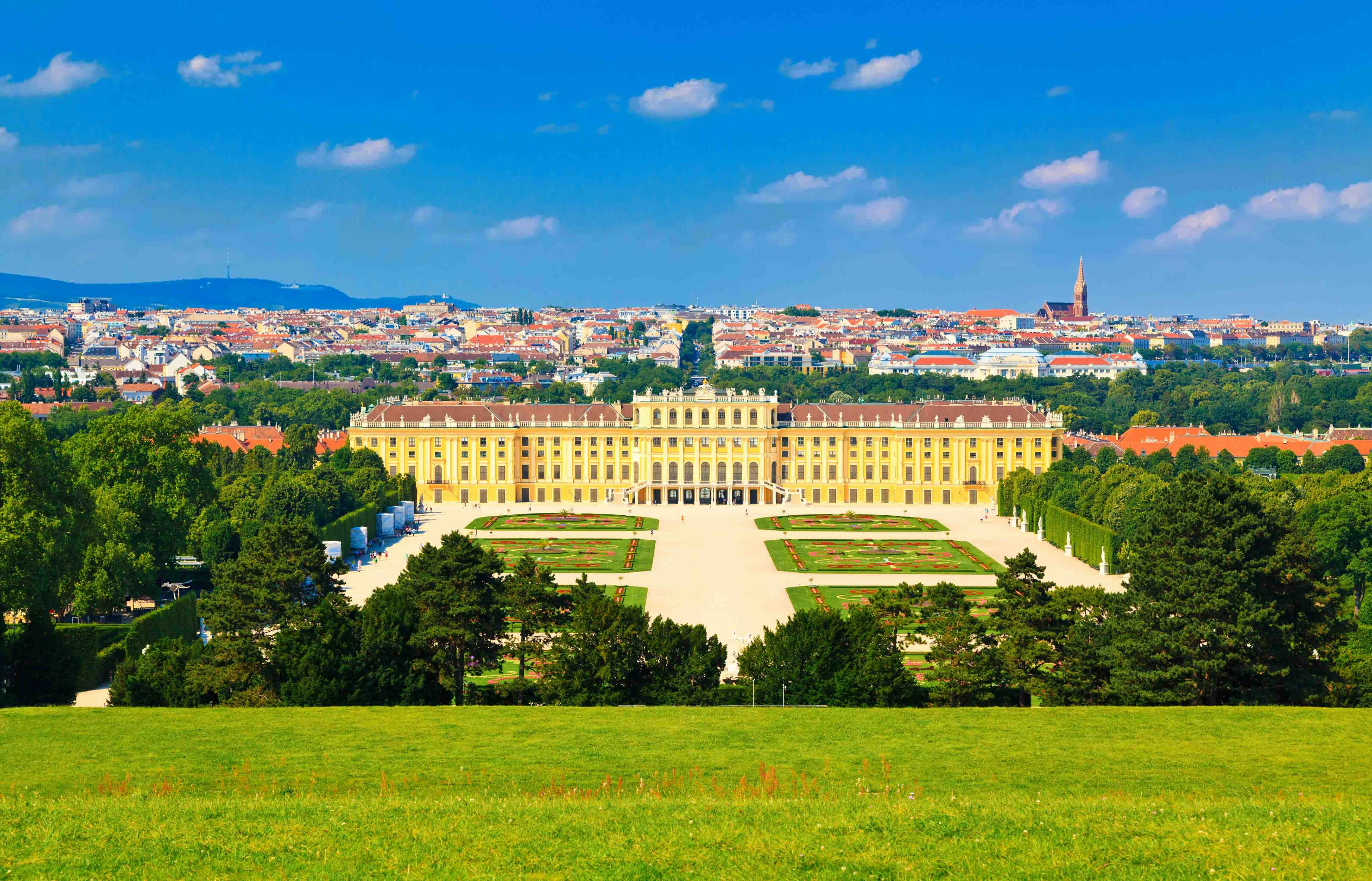 Schönbrunn Palace in Vienna with gardens and cityscape in the background.