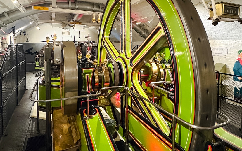 Tower Bridge engine room with large green and brass machinery components.