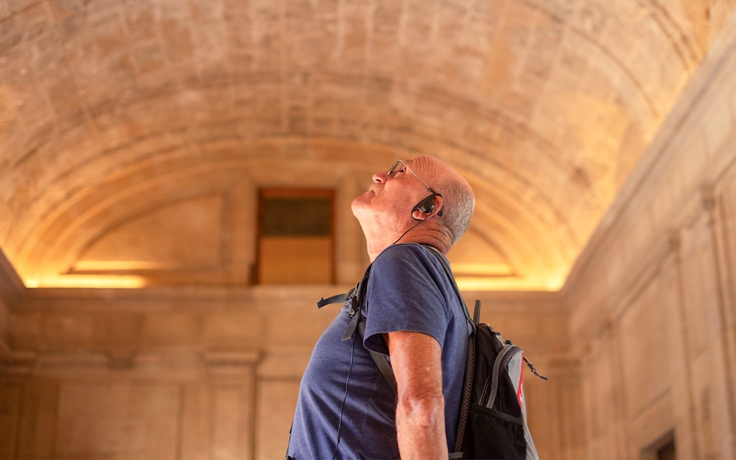 Visitor with audio guide exploring St. Mark's Basilica interior.