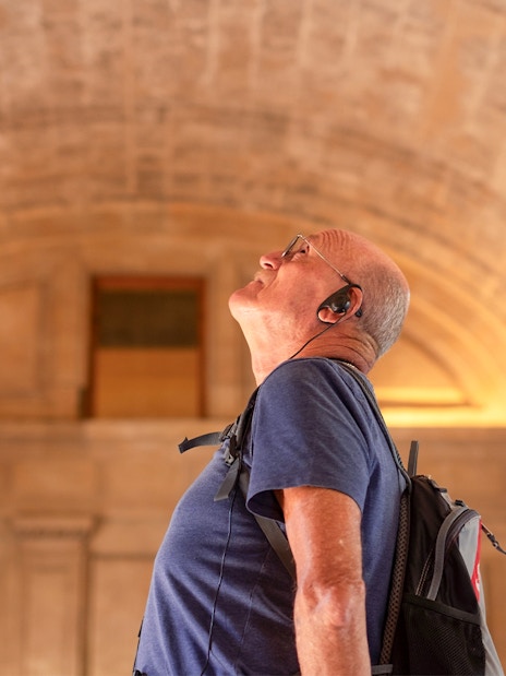 Visitor with audio guide exploring St. Mark's Basilica interior.