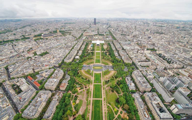 Aerial view of Paris from the Eiffel Tower, showcasing the Champ de Mars and cityscape.