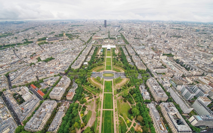Aerial view of Paris from the Eiffel Tower, showcasing the Champ de Mars and cityscape.