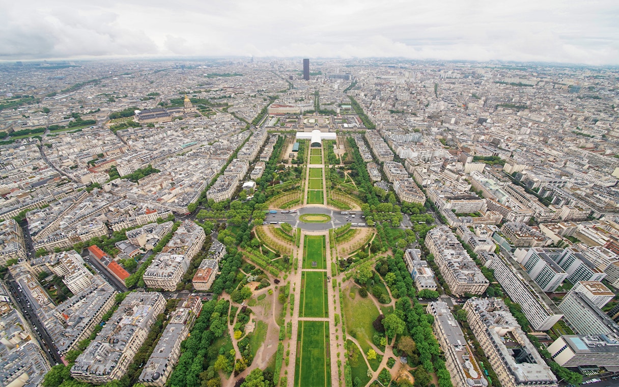Aerial view of Paris from the Eiffel Tower, showcasing the Champ de Mars and cityscape.