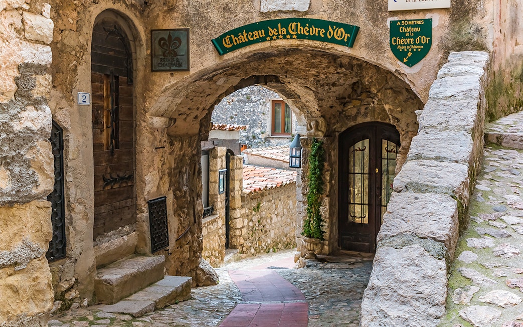 Stone archway and cobblestone path in Eze, leading to Château de la Chèvre d'Or.