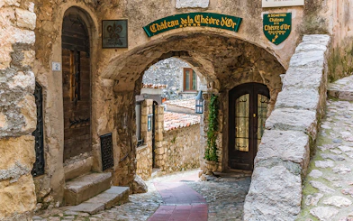 Stone archway and cobblestone path in Eze, leading to Château de la Chèvre d'Or.