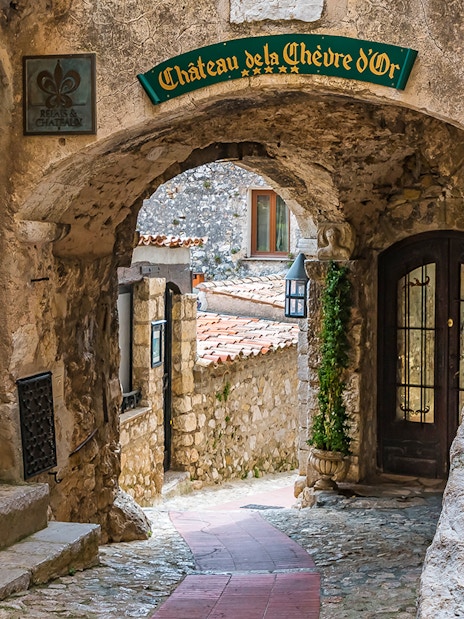 Stone archway and cobblestone path in Eze, leading to Château de la Chèvre d'Or.