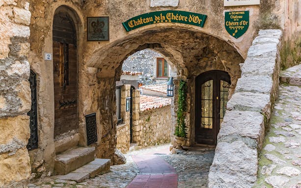 Stone archway and cobblestone path in Eze, leading to Château de la Chèvre d'Or.