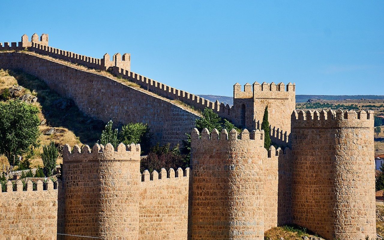 Walls of Ávila with crenellated towers and stone fortifications in Spain.