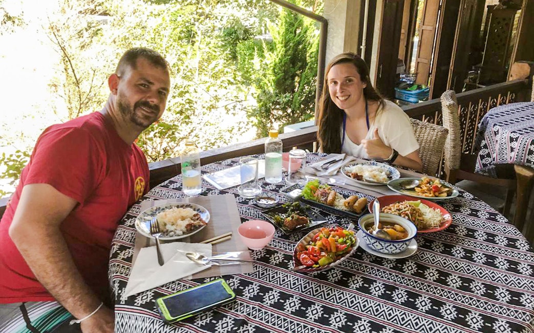 Dining experience at Chiang Mai Elephant Sanctuary with traditional Thai dishes on a patterned table.