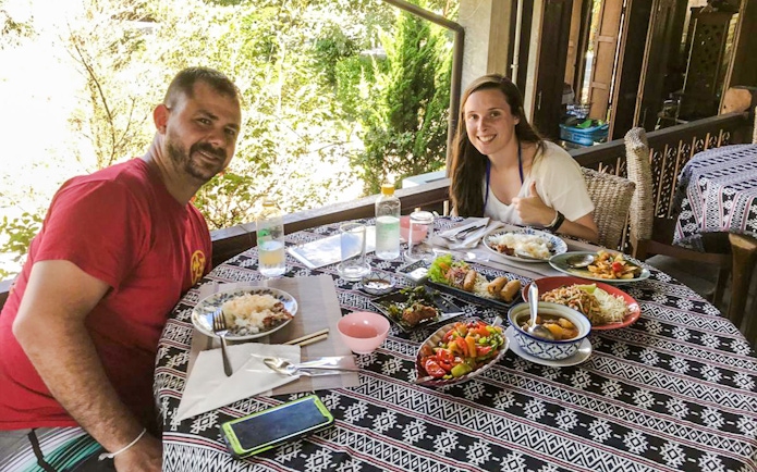 Dining experience at Chiang Mai Elephant Sanctuary with traditional Thai dishes on a patterned table.
