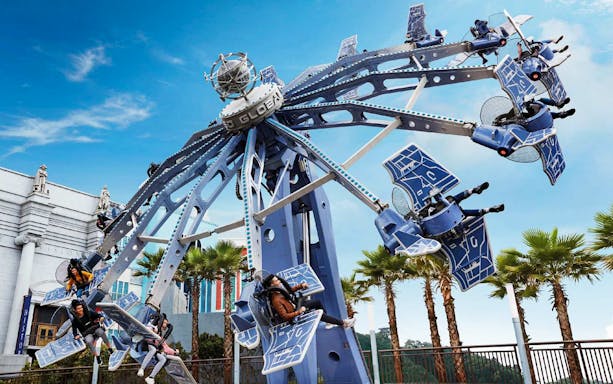 Visitors enjoying a thrilling ride at Skyworld Theme Park.