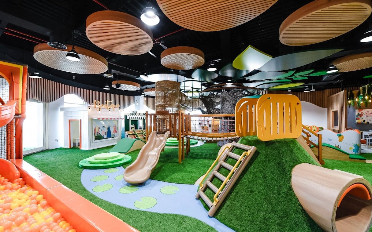 Indoor play area with slides and climbing structures at Orange Wheels, Global Village, Dubai.