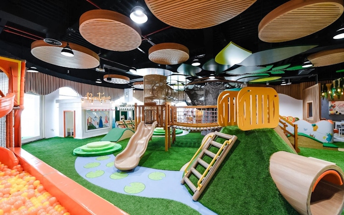 Indoor play area with slides and climbing structures at Orange Wheels, Global Village, Dubai.