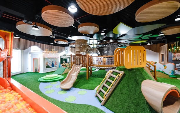 Indoor play area with slides and climbing structures at Orange Wheels, Global Village, Dubai.