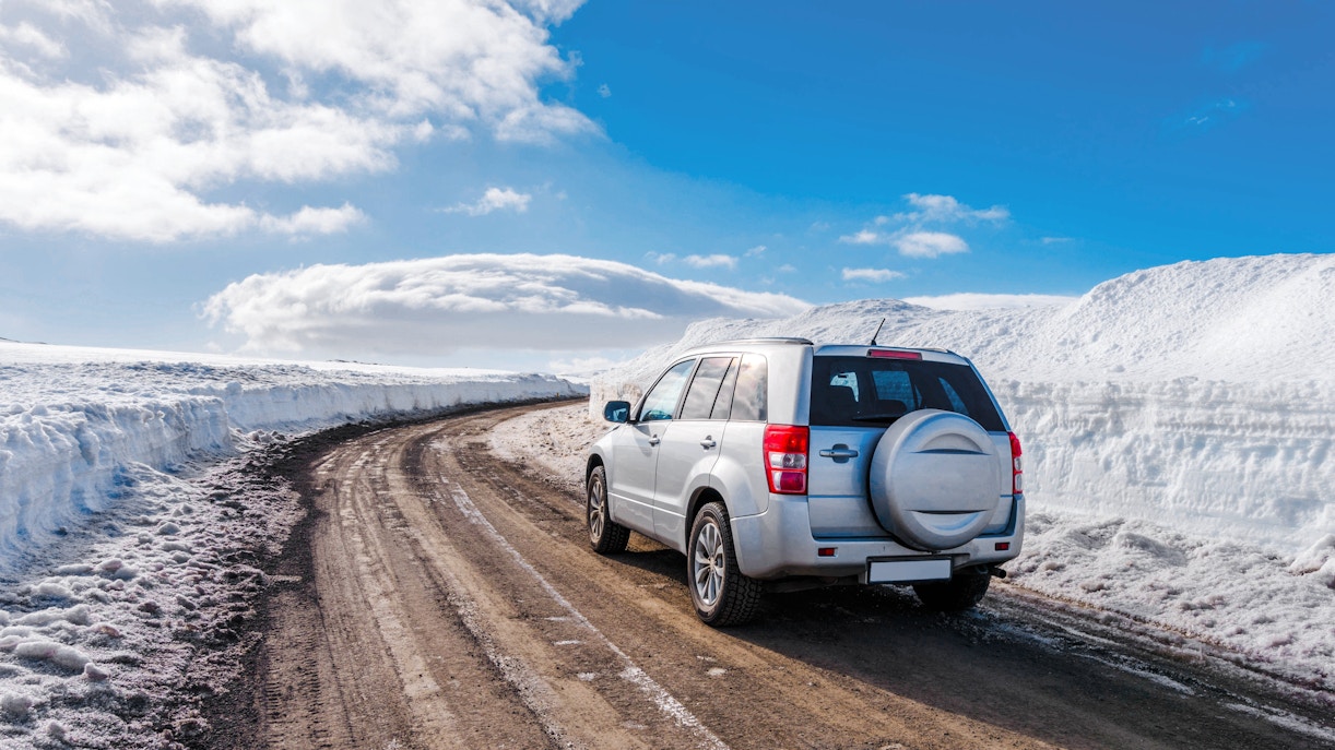SUV on a snowy road in Iceland, ideal for car rental exploration.