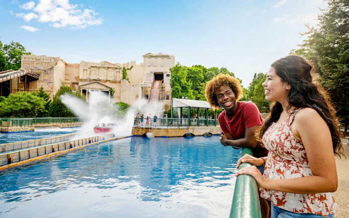 Log flume ride splash at Busch Gardens Williamsburg with smiling visitors nearby.