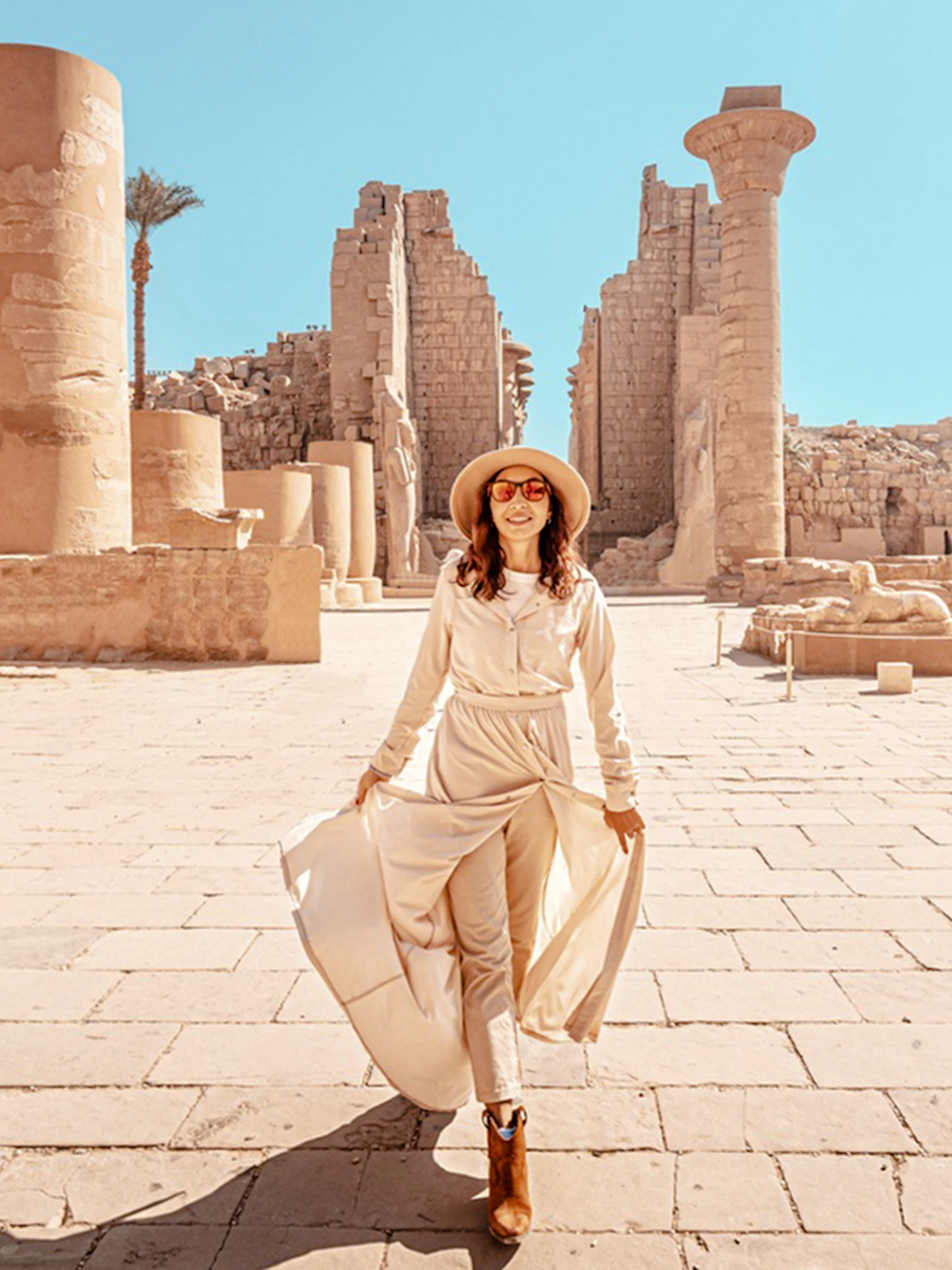 Visitor exploring Karnak Temple ruins in Luxor, Egypt.