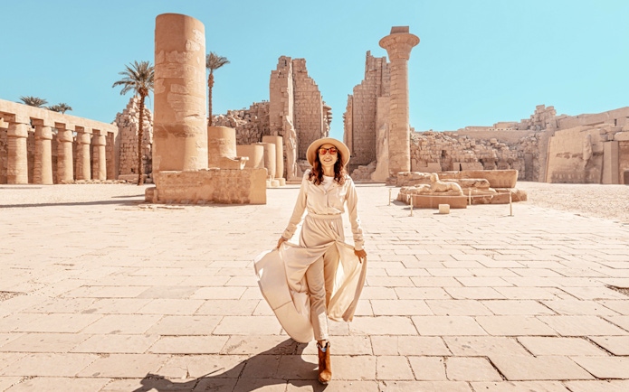 Visitor exploring Karnak Temple ruins in Luxor, Egypt.