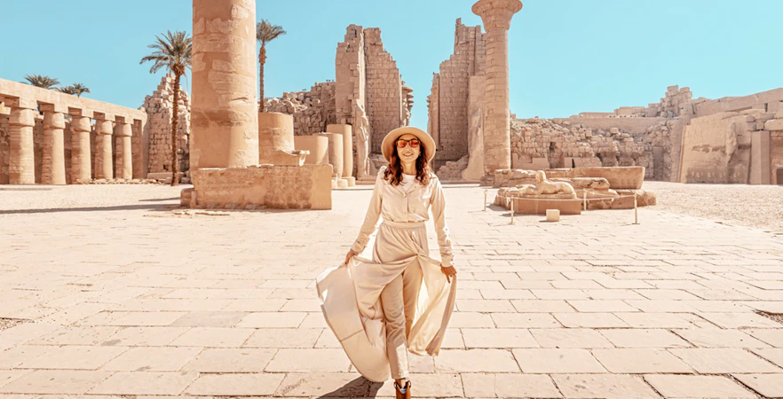 Visitor exploring Karnak Temple ruins in Luxor, Egypt.