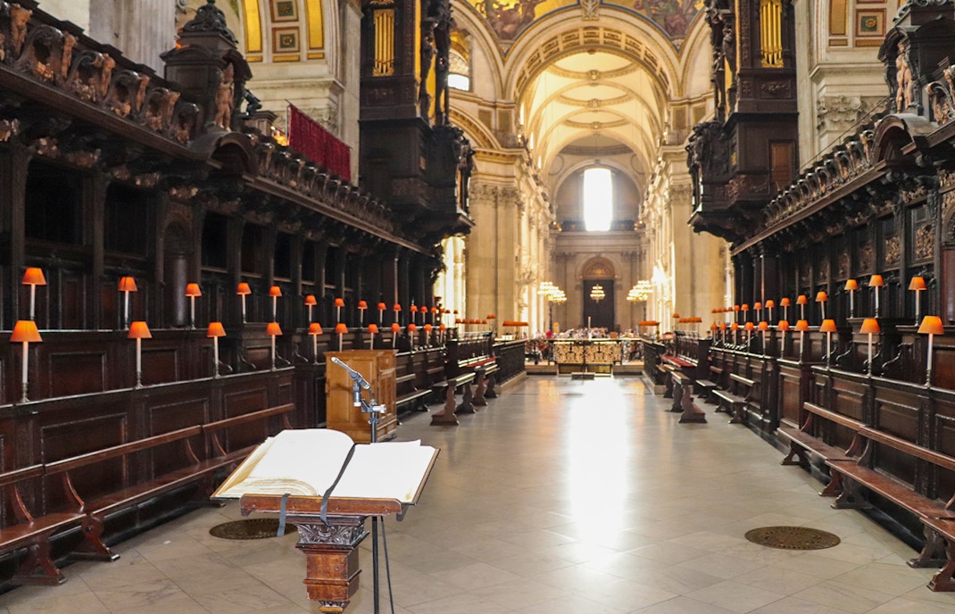 St. Paul's Cathedral crypt with wooden pews and open book on lectern.