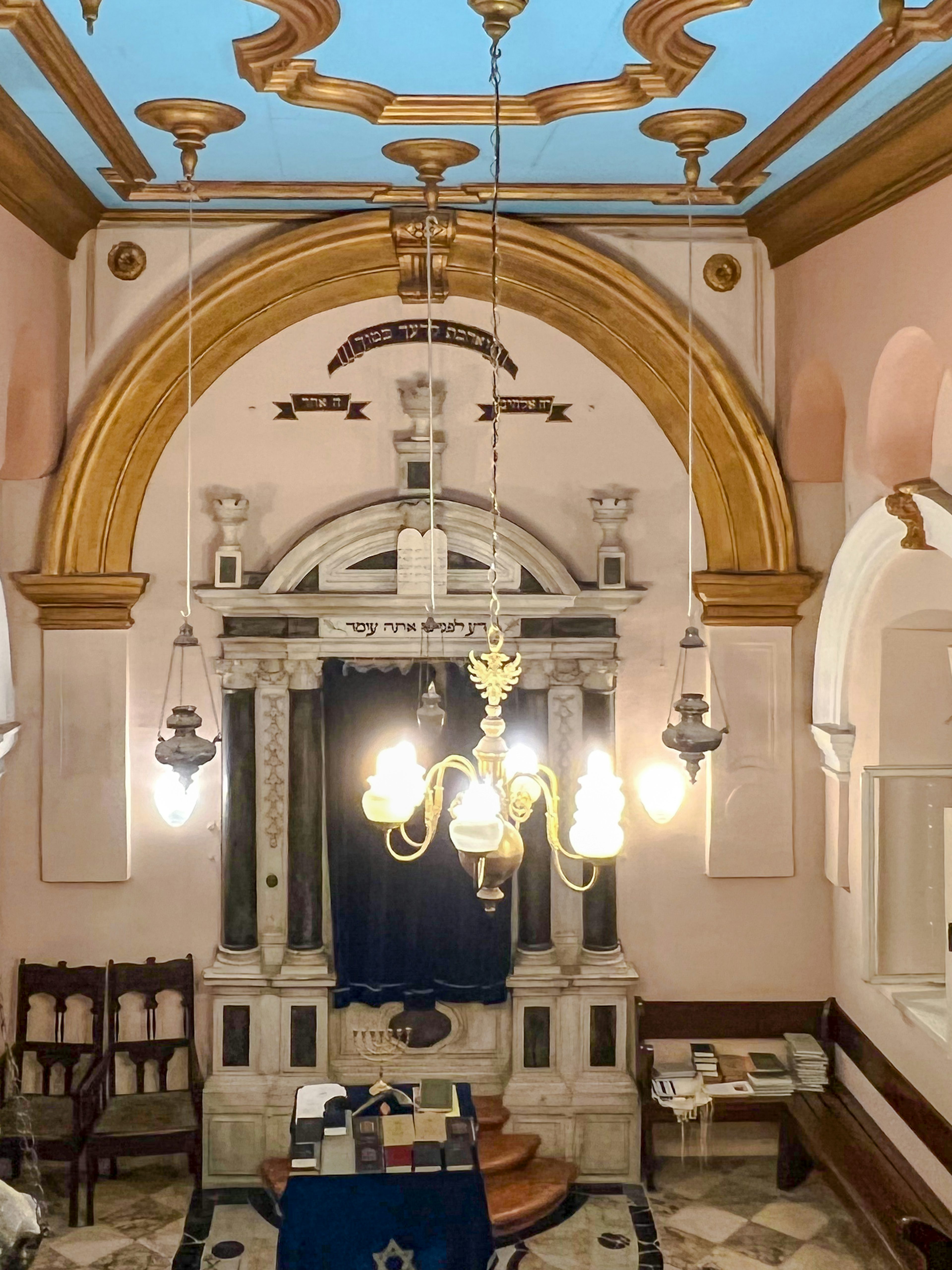 Interior of the historic Synagogue of Split, Croatia, featuring ornate arches and chandeliers.