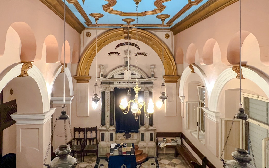 Interior of the historic Synagogue of Split, Croatia, featuring ornate arches and chandeliers.