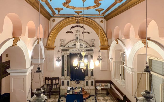 Interior of the historic Synagogue of Split, Croatia, featuring ornate arches and chandeliers.