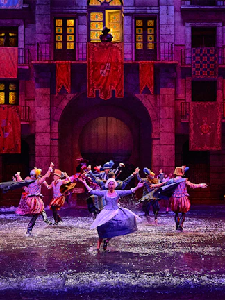 Performers in historical costumes dance in water during Dream of Toledo show.