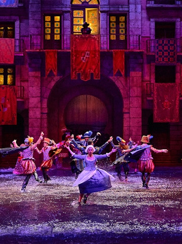 Performers in historical costumes dance in water during Dream of Toledo show.