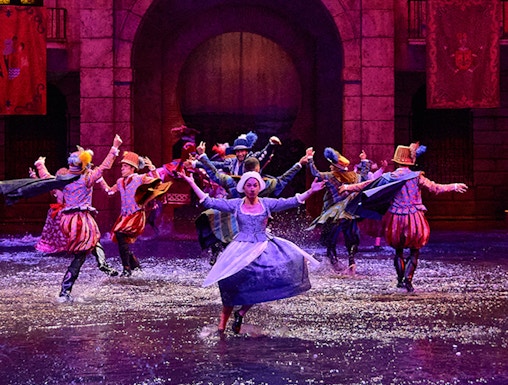 Performers in historical costumes dance in water during Dream of Toledo show.