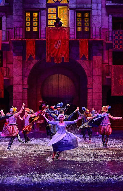 Performers in historical costumes dance in water during Dream of Toledo show.