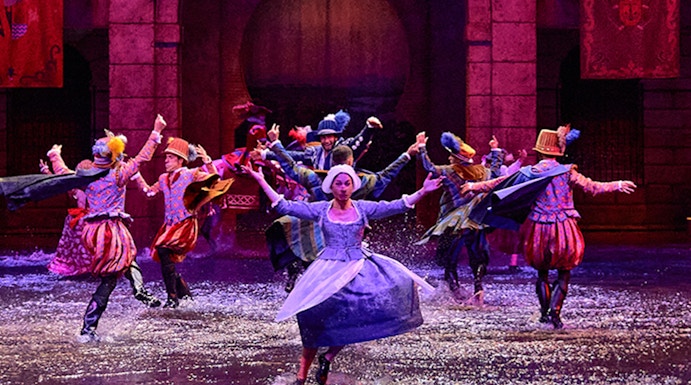 Performers in historical costumes dance in water during Dream of Toledo show.