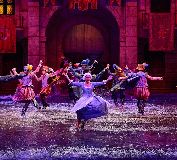 Performers in historical costumes dance in water during Dream of Toledo show.