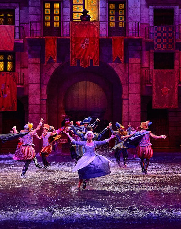 Performers in historical costumes dance in water during Dream of Toledo show.