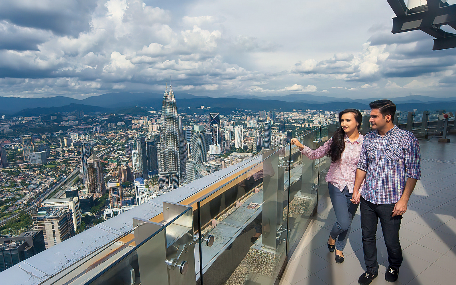 Couple enjoying city view from KL Tower Sky Deck, Kuala Lumpur.