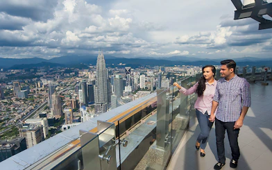 Couple enjoying city view from KL Tower Sky Deck, Kuala Lumpur.