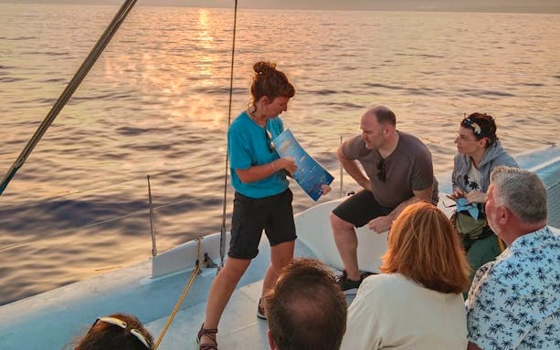 Tourists on a cruise boat in Lanzarote listening to a guide before whale and dolphin watching.
