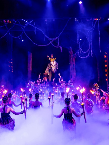 Dancers with torches performing on stage at Phuket Fantasea, Thailand.
