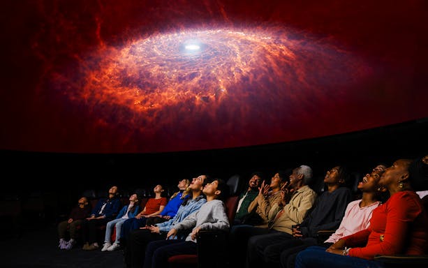 Visitors watching a galaxy projection at Encounters in the Milky Way exhibit, American Museum of Natural History.