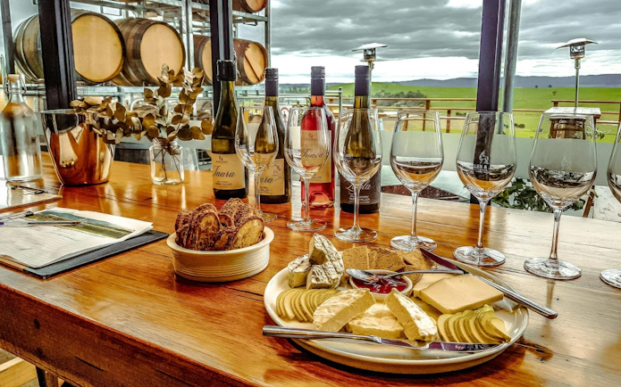Wine tasting setup with cheese platter and wine bottles at Yarra Valley winery.