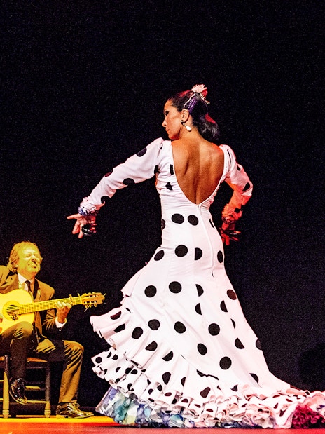 Flamenco dancer performing on stage with musicians during Emociones show.