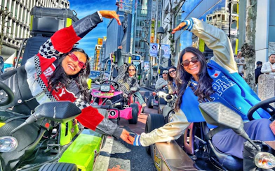 People in go-karts at Shibuya Crossing, Tokyo, enjoying a city tour.