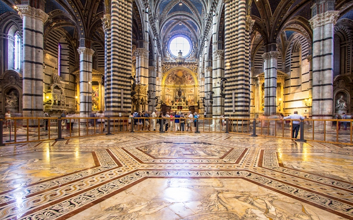 Siena Cathedral interior with striped columns and ornate marble floor, Italy.