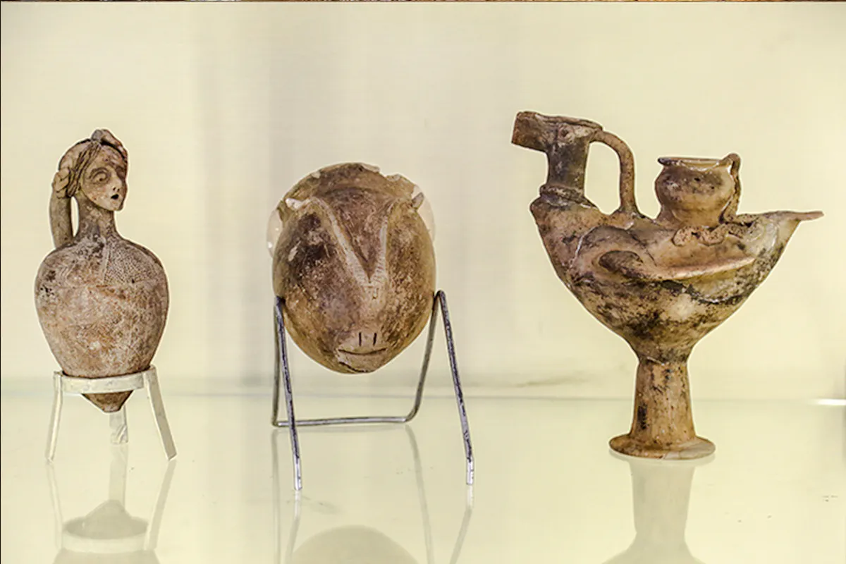 Ancient pottery artifacts displayed in Amman museum during city sightseeing tour.