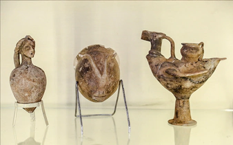 Ancient pottery artifacts displayed in Amman museum during city sightseeing tour.