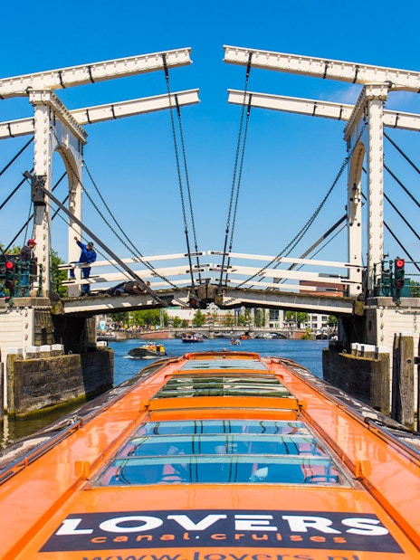 Canal cruise boat approaching Magere Brug in Amsterdam.