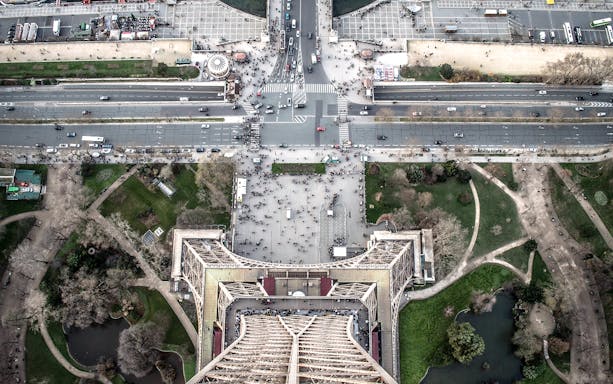 Aerial view from Eiffel Tower overlooking Paris streets and gardens.